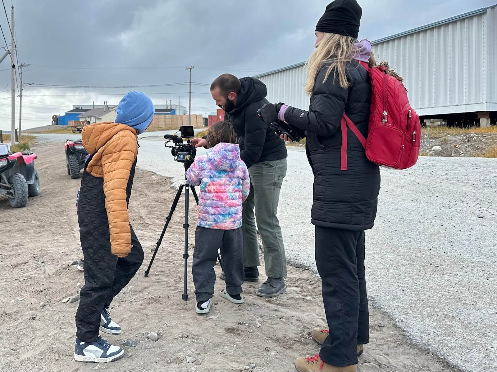 Aphrodite Salas and Luca Caruso-Moro show local residents their mobile journalism recording equipment during a visit to Inukjuak. (Photo by Lina Forero)