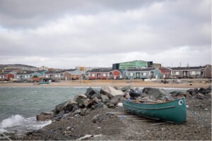 A canoe rests on the shores of the Innuksuak River in Inukjuak, where the river meets Hudson Bay. This community of nearly 2,000 people is transitioning to clean energy, with about 90 per cent of homes already switched to electric heating through the Innavik Hydro project. The community aims to reach net zero by 2030.